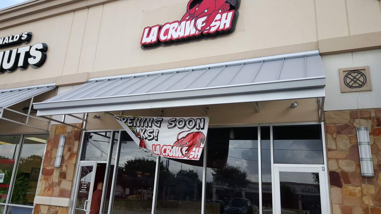 LA Crawfish restaurant storefront with "Opening Soon" banner, located near McDonald's.