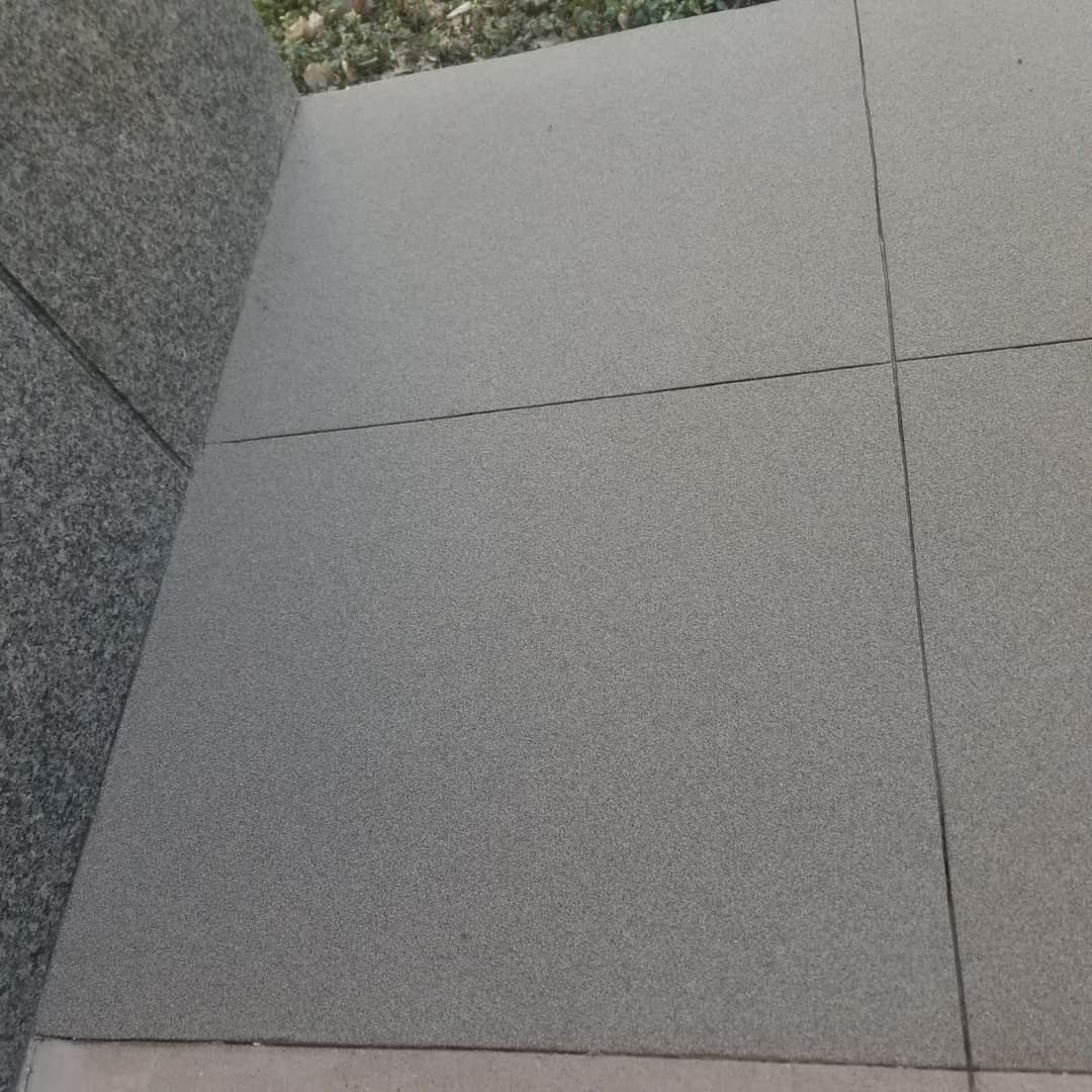 Textured gray flooring tiles with a smooth finish and tight seams, showcasing modern design.