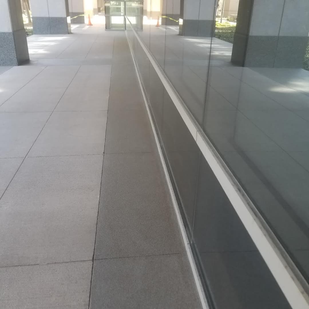 Wide walkway with reflective glass building façade and clear perspective lines.