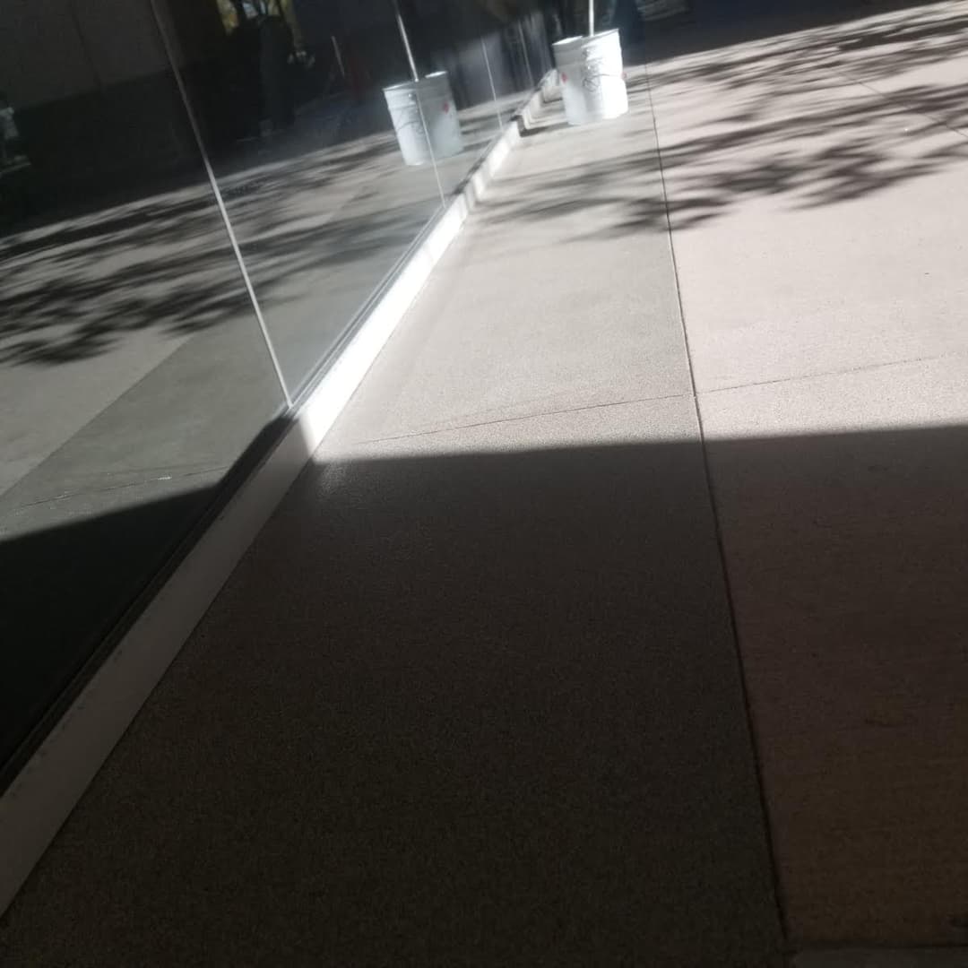 Interior flooring with light and shadow patterns, showcasing a smooth surface and paint buckets.