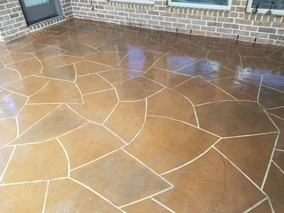 Stamped concrete patio with a decorative stone pattern and glossy finish.