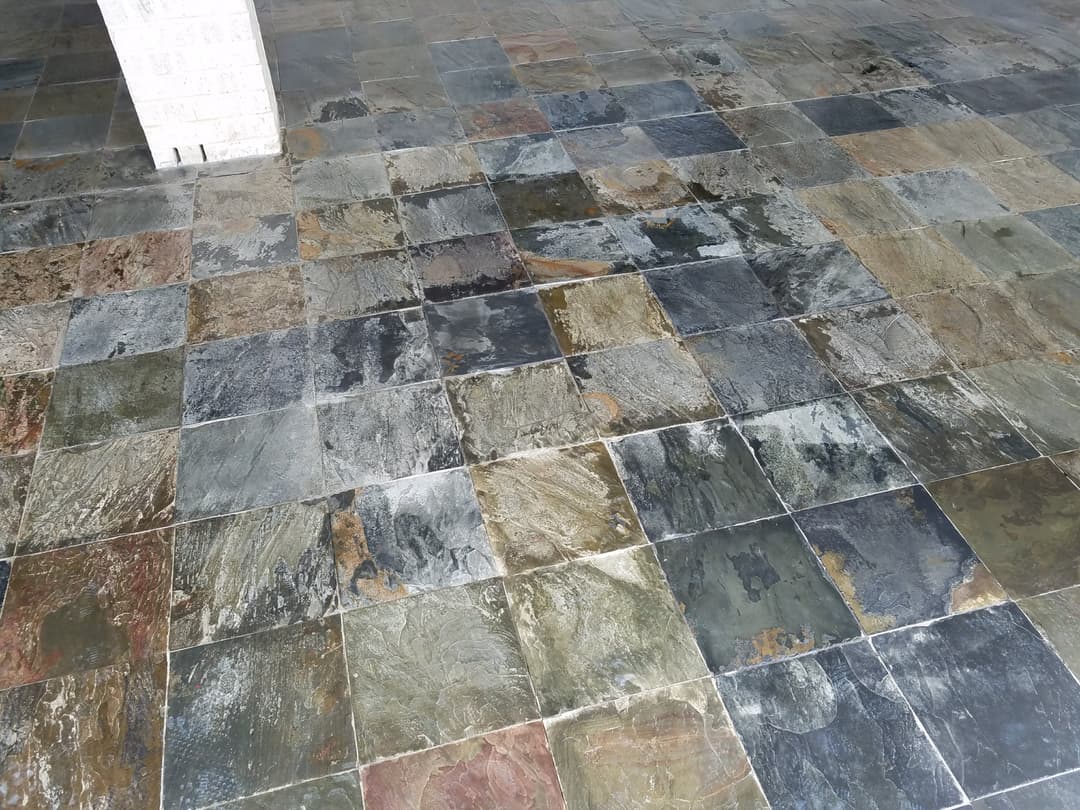 Slate stone floor with various colors and textures in a spacious indoor setting.