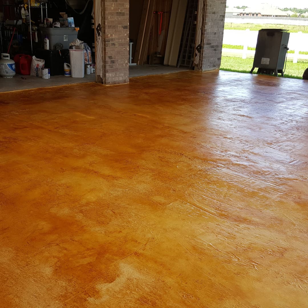 Concrete garage floor with a vibrant orange finish, showcasing a polished texture and clean lines.
