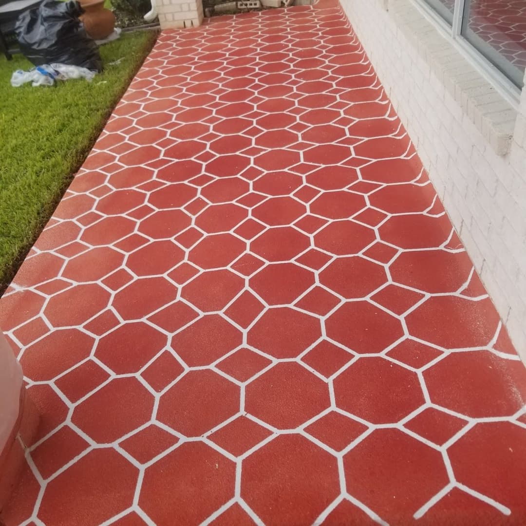 Red and white hexagon patterned concrete patio with green grass in the background.