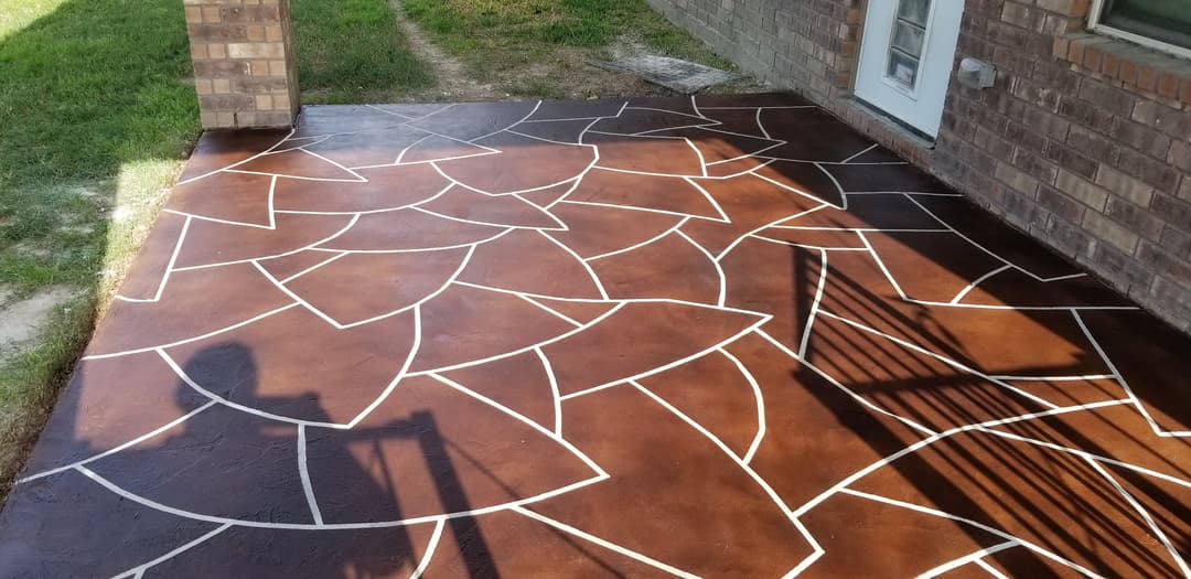 Decorative stained concrete patio with geometric pattern and white outlines.