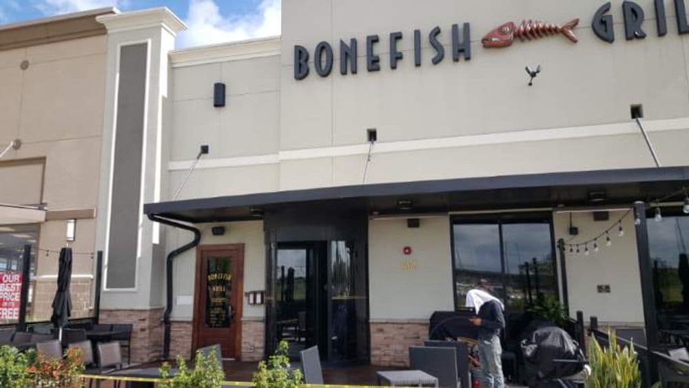 Exterior view of Bonefish Grill restaurant with patio seating and signage.