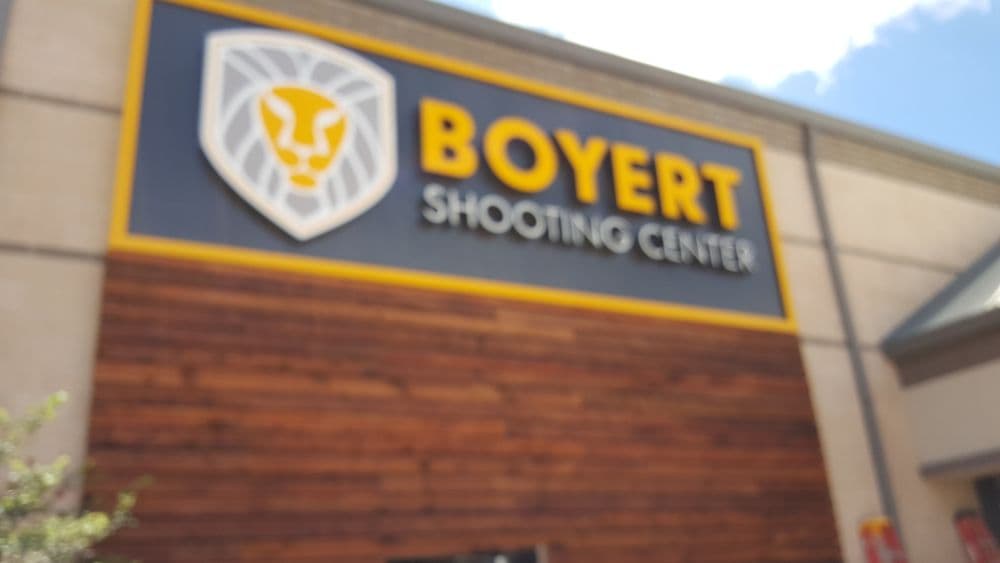 Boyert Shooting Center sign featuring a lion logo and wooden accents, outdoor setting.